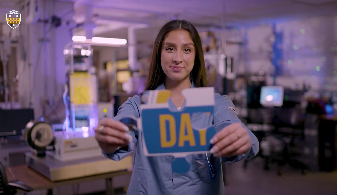 A person holds out a puzzle piece with a lab in the background