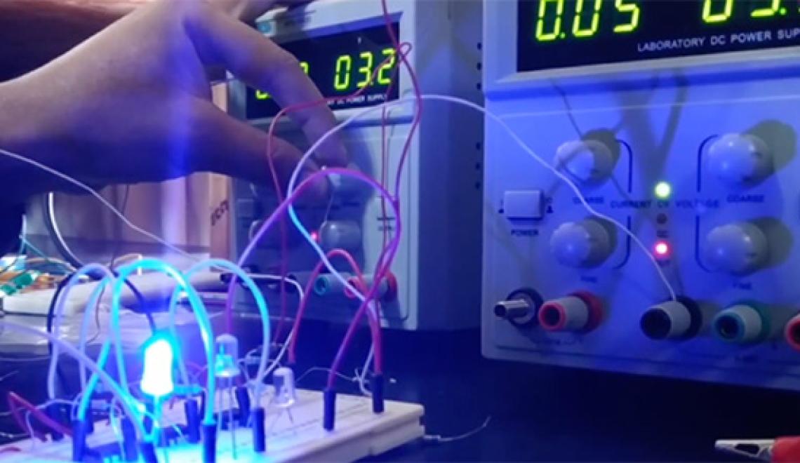 A hand turns a knob on an electrical panel