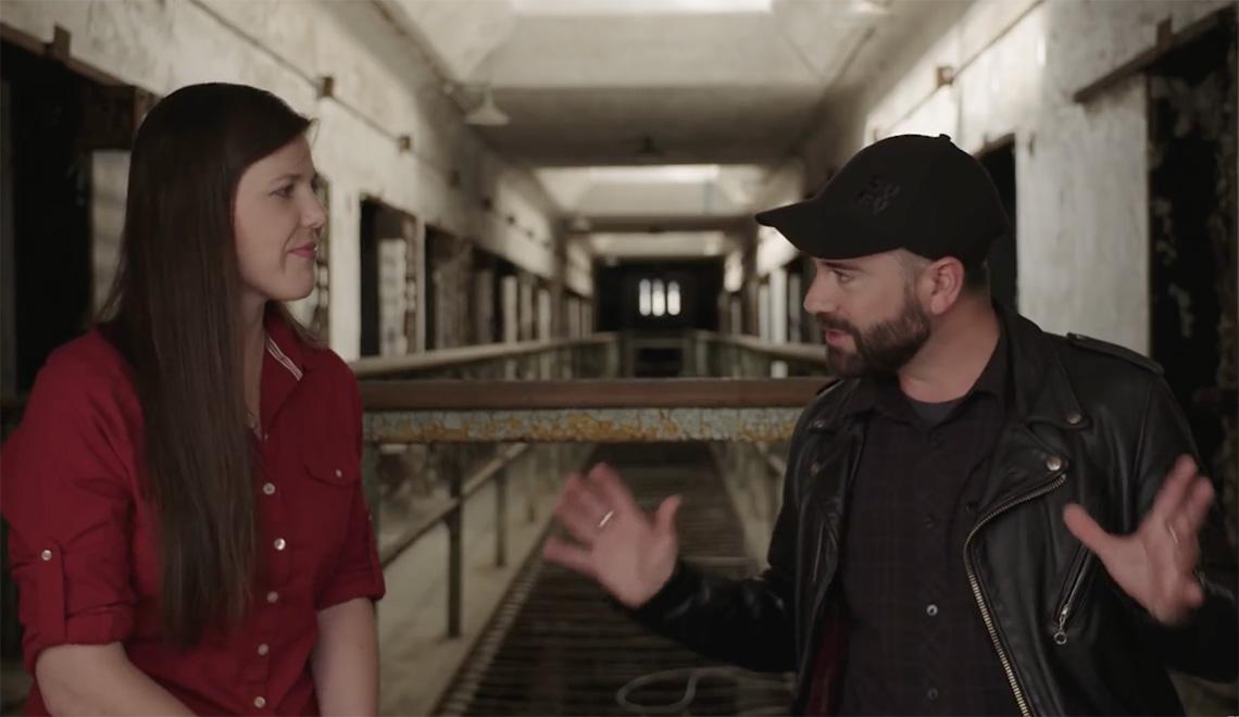 Two people talk in the Eastern State Penitentiary