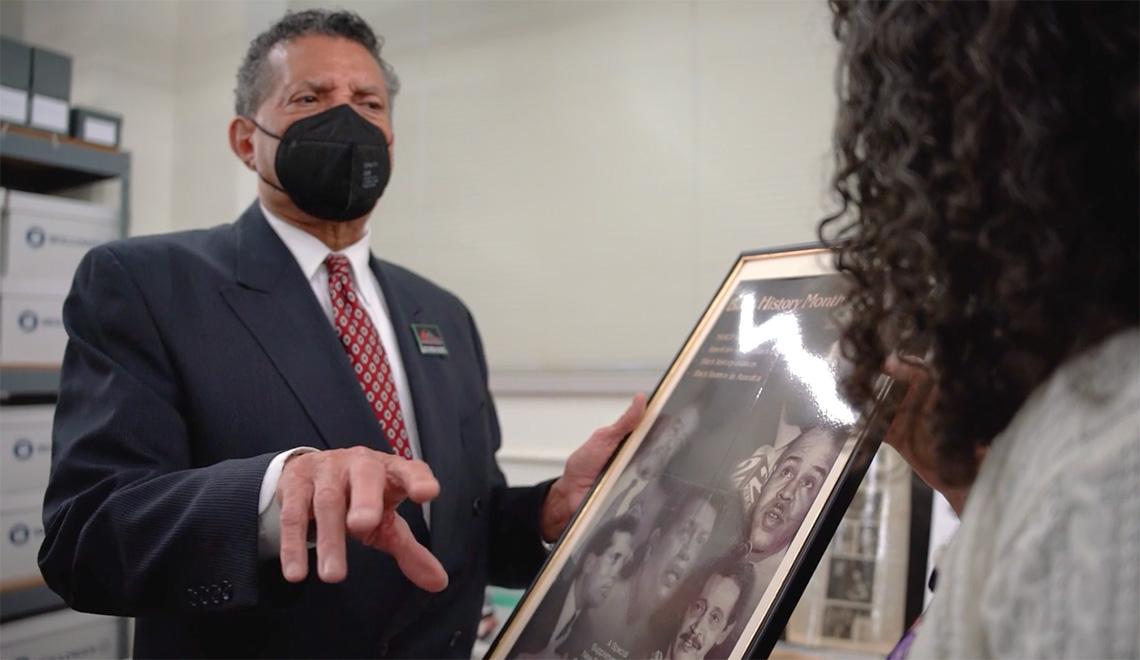 Stevens gestures toward a framed poster he's holding up